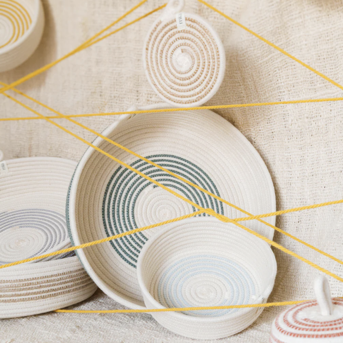 Woven baskets with circular patterns on a textured surface