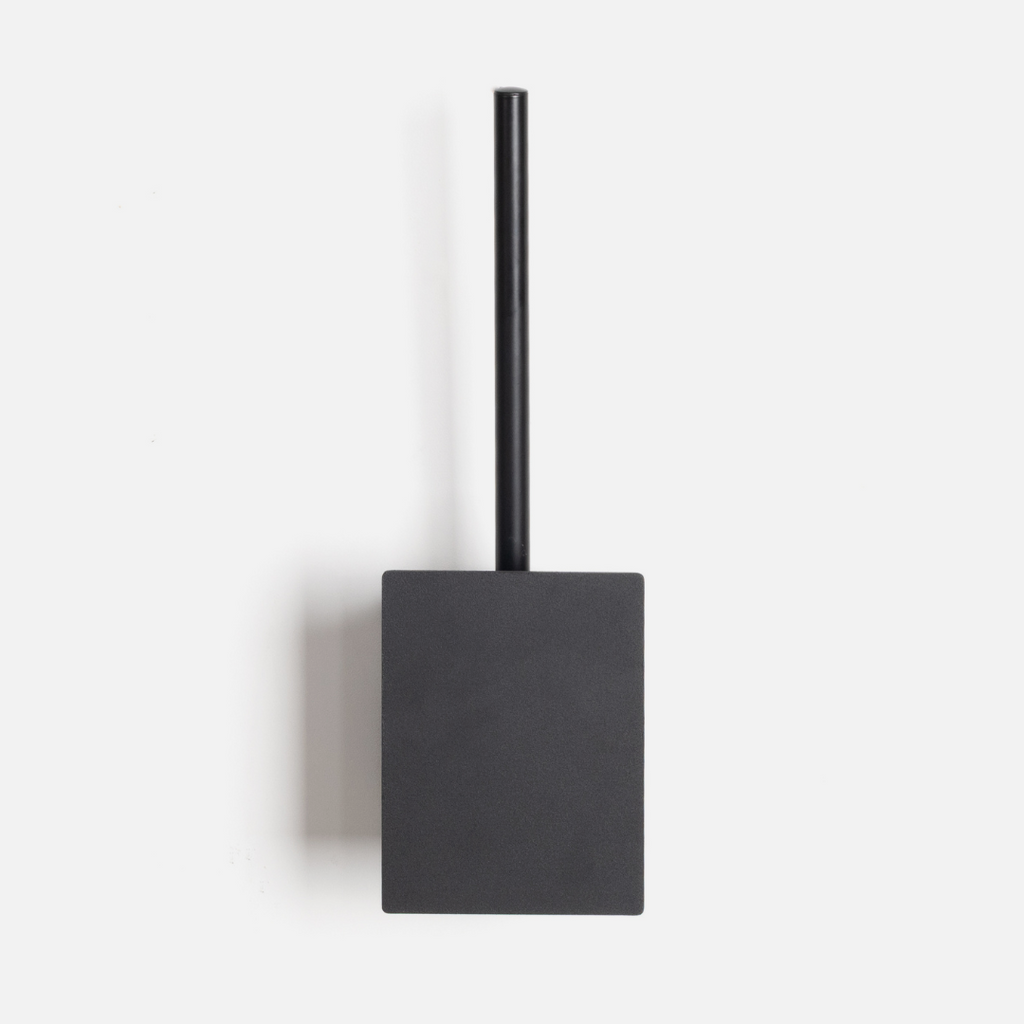 Black wall-mounted toilet brush holder set on a white background